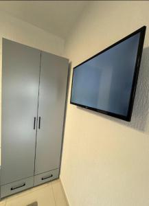 a flat screen tv on a wall next to a cabinet at Reaal Apartaments 1 in Mazgit