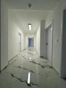 an empty hallway with marble floors and white walls at Reaal Apartaments 1 in Mazgit