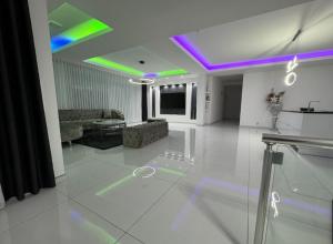 a living room with purple and green lights on the ceiling at Reaal Apartaments 1 in Mazgit +1 photo
