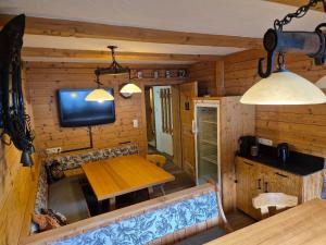 a dining room with a table and a tv in a cabin at Petererhof in Ellmau