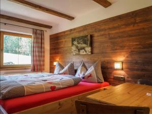 a bedroom with a bed and a wooden wall at Petererhof in Ellmau