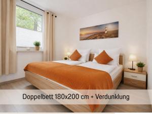 a bedroom with a bed with an orange blanket at Sonnendeck - Familienzeit im Wald in Dahlen