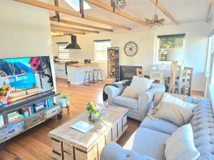 a living room with couches and a tv at Beach House in Surf Beach