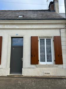 a building with a door and two windows on it at Chez Rémi in Écommoy