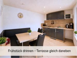 a kitchen and a dining room with a table and chairs at Sonnendeck - Familienzeit im Wald in Dahlen +14 photos
