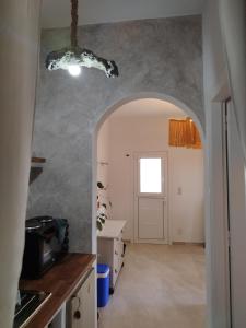 a kitchen with an archway leading into a room with a door at Alexandria Aegean View in Gavrio