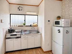 a kitchen with a white refrigerator and a microwave at 晴の川 in Wakayama