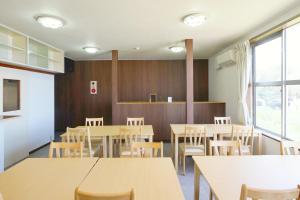 a dining room with wooden tables and chairs at 海凪旅館 in Tateyama