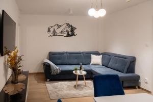 a living room with a blue couch and a table at ADELA VIP Nezábudka - Tiché krídlo, 45m2 a TOP spánok in Tatranska Strba