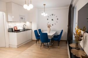 a kitchen with a table and chairs and a clock on the wall at ADELA VIP Nezábudka - Tiché krídlo, 45m2 a TOP spánok in Tatranska Strba