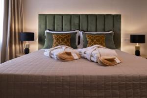 a bedroom with a large bed with two robes at Giorgio Raggi Hospitality in Terni