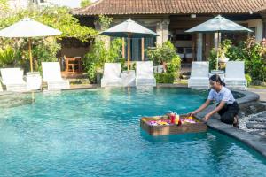 a woman in a pool with a basket in the water at Capung Cottages in Ubud +110 photos