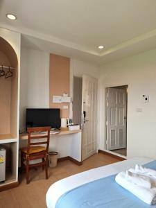 a bedroom with a bed and a desk with a computer at Yukata Space in Sathani Nakhon Si Thammarat +26 photos