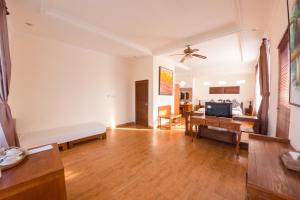 a living room with a couch and a tv at Capung Cottages in Ubud