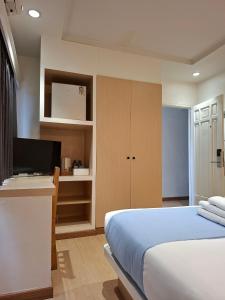 a bedroom with a bed and a flat screen tv at Yukata Space in Sathani Nakhon Si Thammarat
