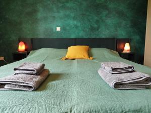 a green bed with towels on it with two lamps at Alexandria Aegean View in Gavrio