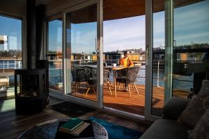 a man sitting at a table on the deck of a house at Floatinghouse Grasshopper in Klitten