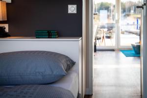 a bedroom with a bed and a door to a balcony at Floatinghouse Grasshopper in Klitten