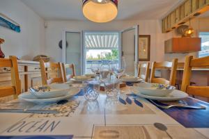 a dining room table with plates and glasses on it at Maison Oléron - Welkeys in Dolus-d'Oléron