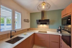 a kitchen with a sink and a stove at Maison Oléron - Welkeys in Dolus-d'Oléron