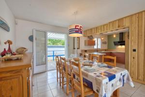 a kitchen and dining room with a table and chairs at Maison Oléron - Welkeys in Dolus-d'Oléron