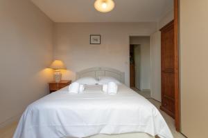 a bedroom with a white bed with two pillows at Maison Oléron - Welkeys in Dolus-d'Oléron