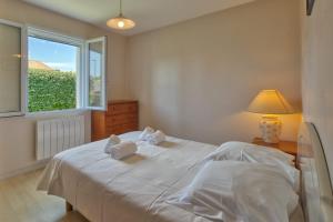 a bedroom with a white bed with a window at Maison Oléron - Welkeys in Dolus-d'Oléron +10 photos