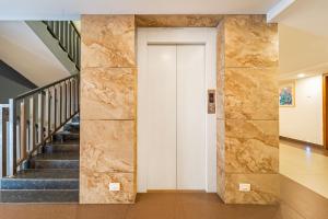 a hallway with stairs and a stone wall at Treebo Medco Mansion in Kozhikode +35 photos