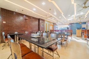 a restaurant with tables and chairs and a brick wall at Treebo Medco Mansion in Kozhikode