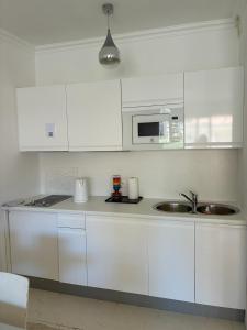 a white kitchen with a sink and a microwave at Monaco Studio "907" in Monte Carlo +14 photos