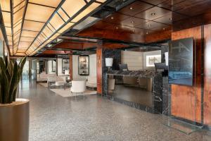 a lobby of a building with tables and chairs at Hotel Ambasciatori in Rimini +112 photos