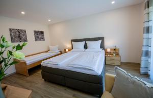 a bedroom with a large bed and a couch at Weingut Erich Serwazi in Mesenich