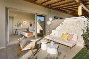 a patio with a couch and a bed in a bedroom at TERTH - Afytos Experience in Afitos