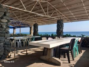 a table and chairs under a pavilion on the beach at White Castle Beach Resort in Iba +11 photos