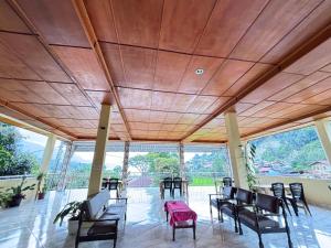 a room with a table and chairs and a large window at Toba Boi in Tuktuk Siadong