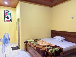 a bedroom with a bed and a fan at Toba Boi in Tuktuk Siadong