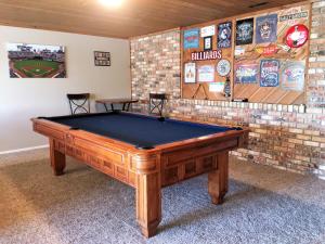 a pool table in a room with a brick wall at Priceless Black Hills View in Rapid City