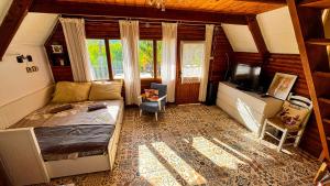 a bedroom with a bed and a tv in it at Jó, hogy itt vagy! in Orfű