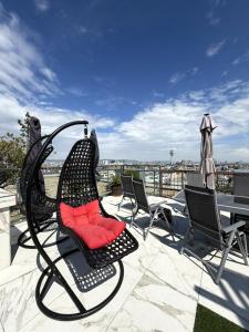 a black chair with a red pillow on a patio at Panorama Apartments Vienna in Vienna