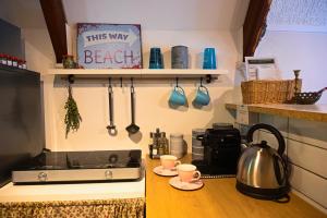 a kitchen with a sink and a stove with two cups at Jó, hogy itt vagy! in Orfű