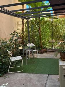 a patio with a table and chairs on a green rug at Monaco Studio #3 with private patio in Beausoleil