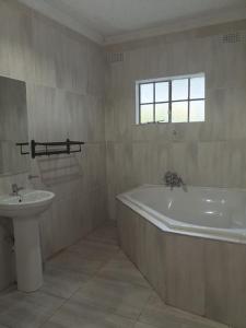 a bathroom with a bath tub and a sink at Alamaison in Umtali +20 photos