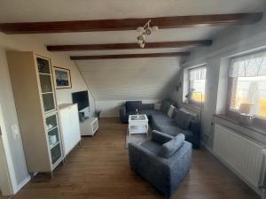 a living room with a couch and a table at Zur Mühle Munkmarsch in Sylt