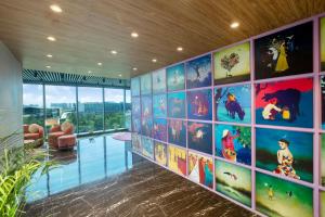 a room with a wall with paintings on it at Plume Hotels, India Expo Mart, Greater Noida in Greater Noida