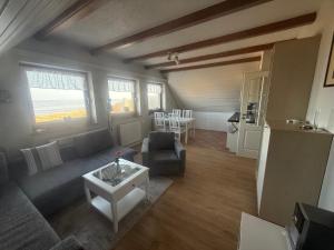 a living room with a couch and a table at Zur Mühle Munkmarsch in Sylt