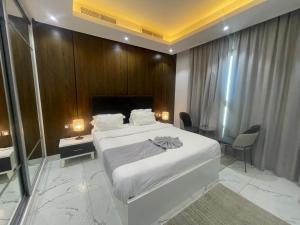 a bedroom with a white bed and a wooden wall at Al Safwa One in Al Ḩadd +98 photos
