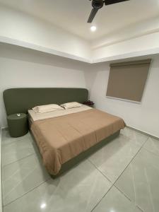 a bedroom with a bed with a green headboard at KD Homes - Elite studio stay in Surat