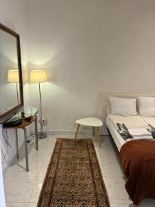 a bedroom with a bed and a mirror and a table at Monaco Studio #3 with private patio in Beausoleil