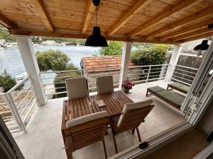 a patio with a table and chairs on a balcony at Holiday Home Magazin in Slano +26 photos