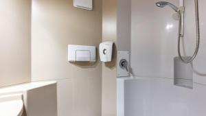 a white bathroom with a shower and a toilet at Premiere Classe Dreux in Dreux +28 photos